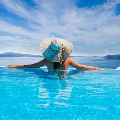 Woman in an infinity pool overlooking the ocean